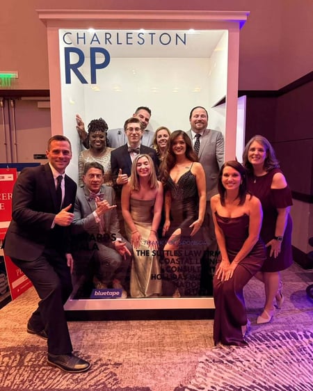 Real estate agents pose at a photobooth